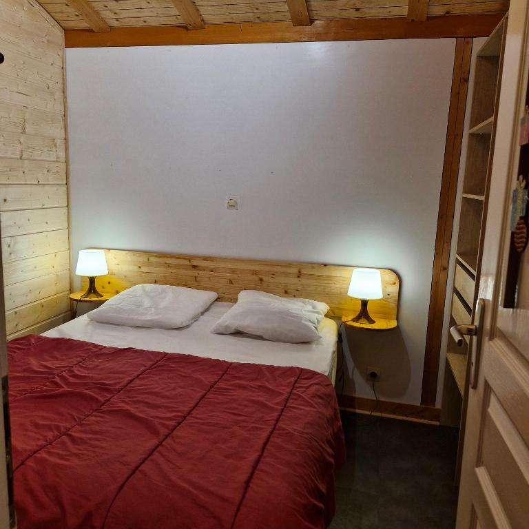 a bedroom with a large bed with two lamps at Chalet Jonquille 1 in Plombières-les-Bains