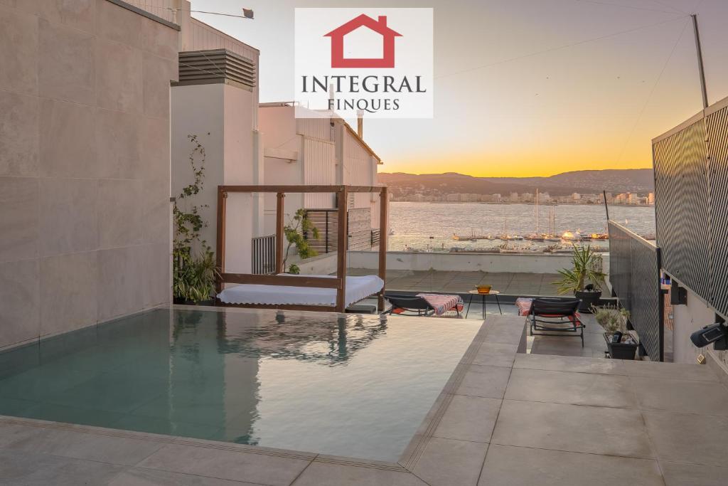 een zwembad op het dak van een gebouw met zonsondergang bij L'Àtic de Palamós in Palamós