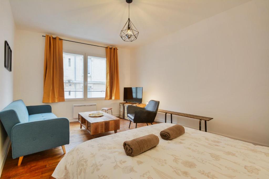 a bedroom with a bed and two chairs and a table at Appartement Place Stanislas 2 in Nancy