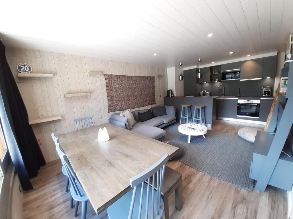 Il comprend un salon et une cuisine avec une table et un canapé. dans l'établissement Appartement skis aux pieds, 3 chambres, rénové, idéalement situé près des commerces à Courchevel 1650 - FR-1-514-61, à Courchevel