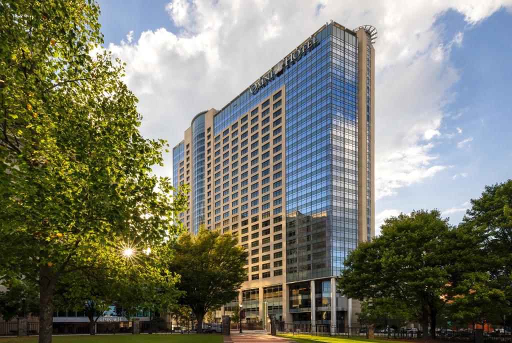 a tall glass building with trees in front of it at Omni Atlanta Hotel at Centennial Park in Atlanta