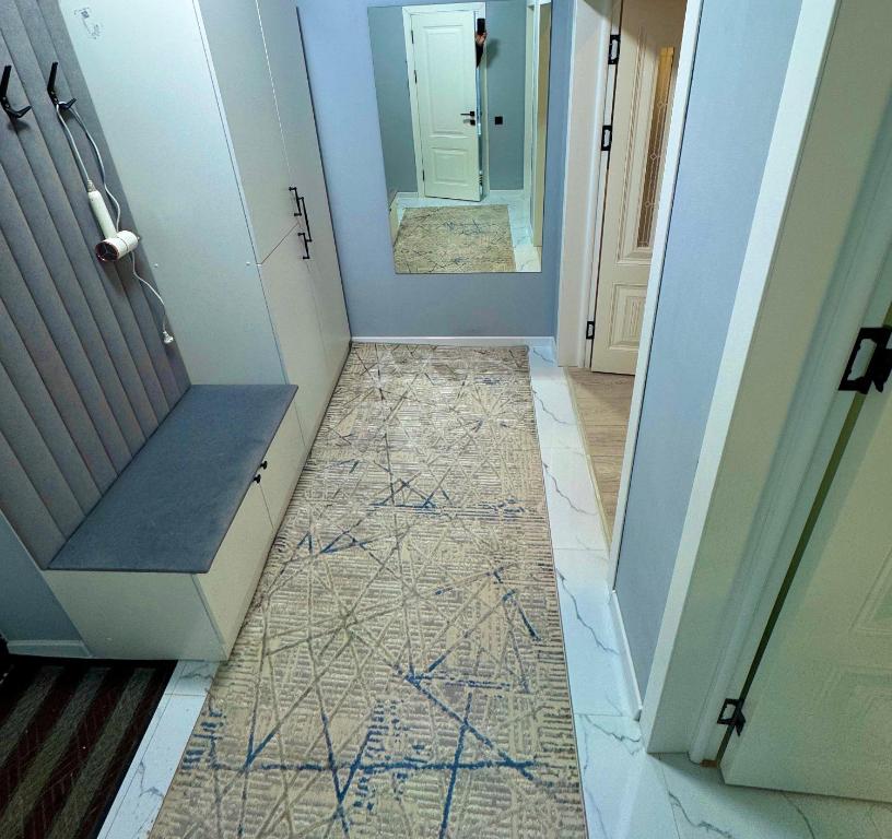 pasillo con suelo de baldosa y puerta con espejo en Luxury Apartments, en Bishkek