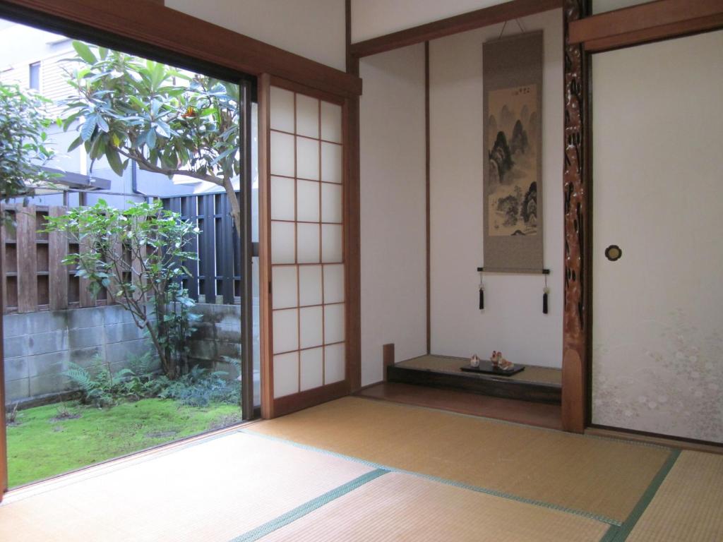 een toegang tot een kamer met een glazen schuifdeur bij Enman Guest House Osaka in Osaka