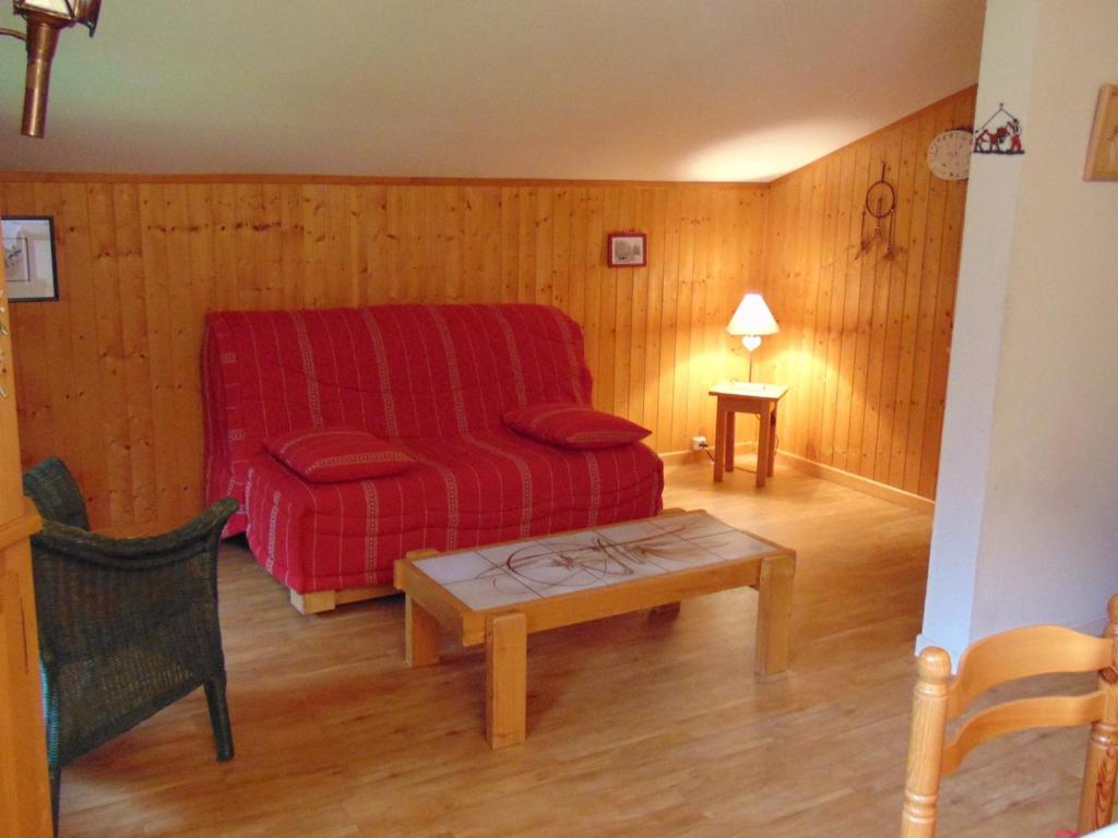 un salon avec un canapé rouge et une table dans l'établissement Bel appartement rénové avec vue sur le Mont-Blanc, parking couvert, animaux admis - FR-1-517-51, à Chamonix-Mont-Blanc