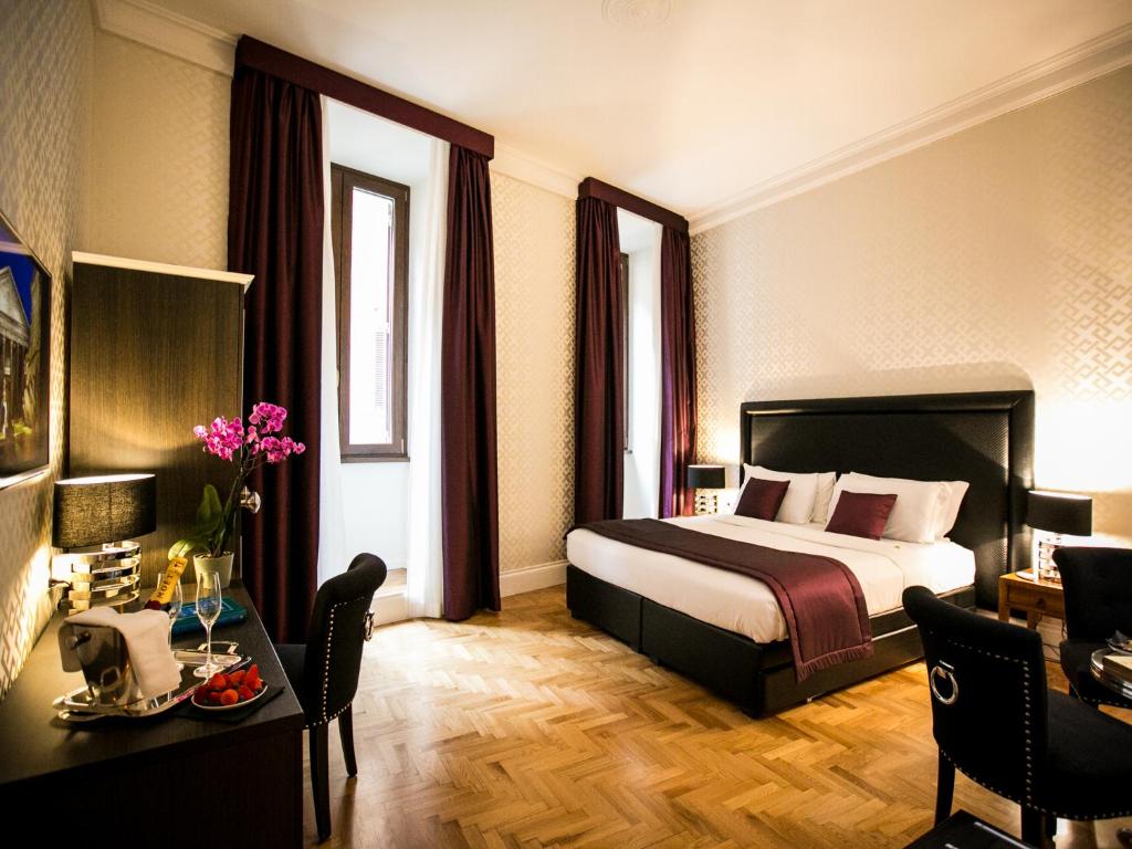 a hotel room with a bed and a desk and a room at Minerva Relais in Rome