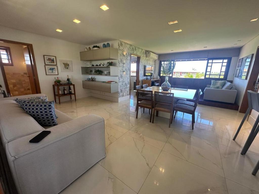 Una sala de estar con un sofá y un comedor. en Luxury house at Praia do Forte, en Mata de Sao Joao