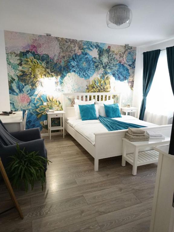 a bedroom with a white bed and floral wallpaper at Old Town Cozy Nest in Sibiu