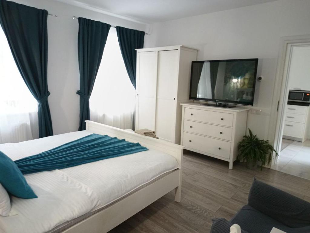 a bedroom with a bed with a television and a dresser at Old Town Cozy Nest in Sibiu