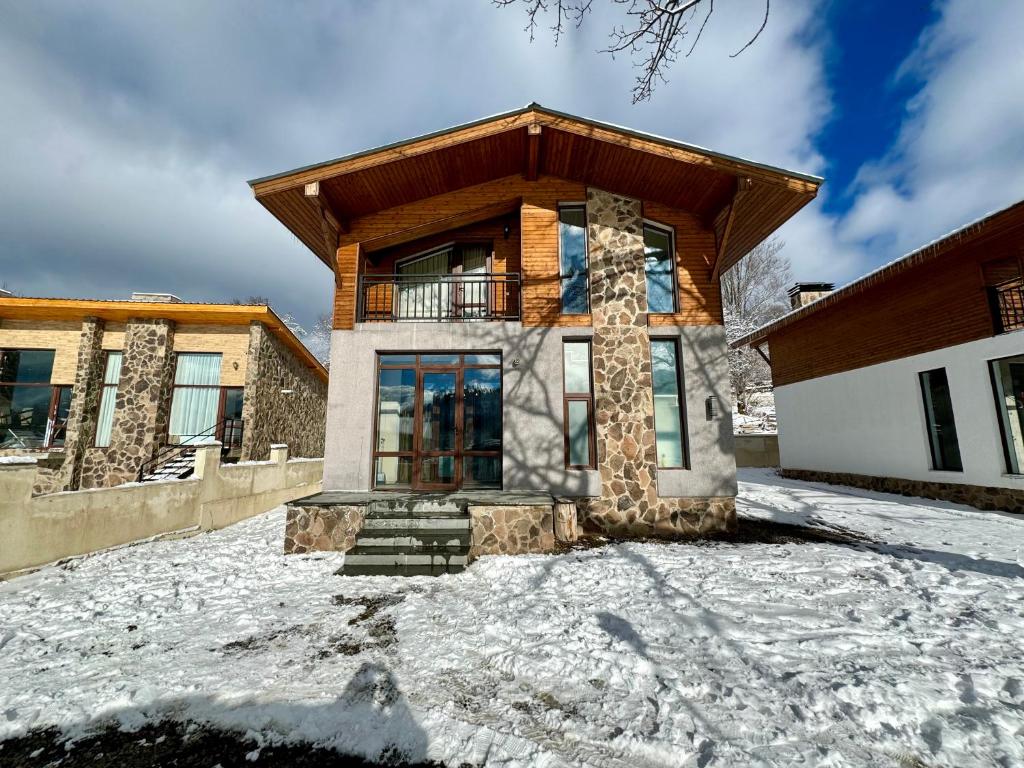 una casa in inverno con neve per terra di Villa on the Edge of the Forest a Bakuriani