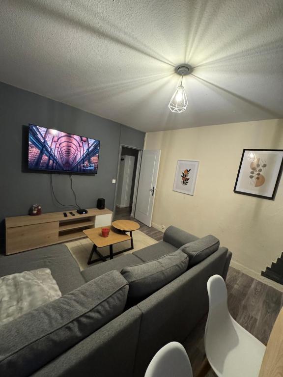 un salon avec un canapé et une télévision à écran plat dans l'établissement Appartement Cosy, à Montceau-les-Mines