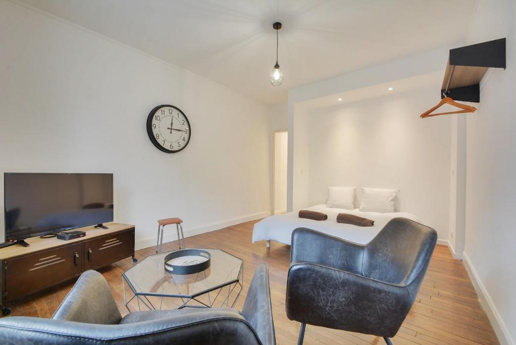 une chambre avec un lit, un canapé et une télévision dans l'établissement Apartment Place Stanislas 3, à Nancy