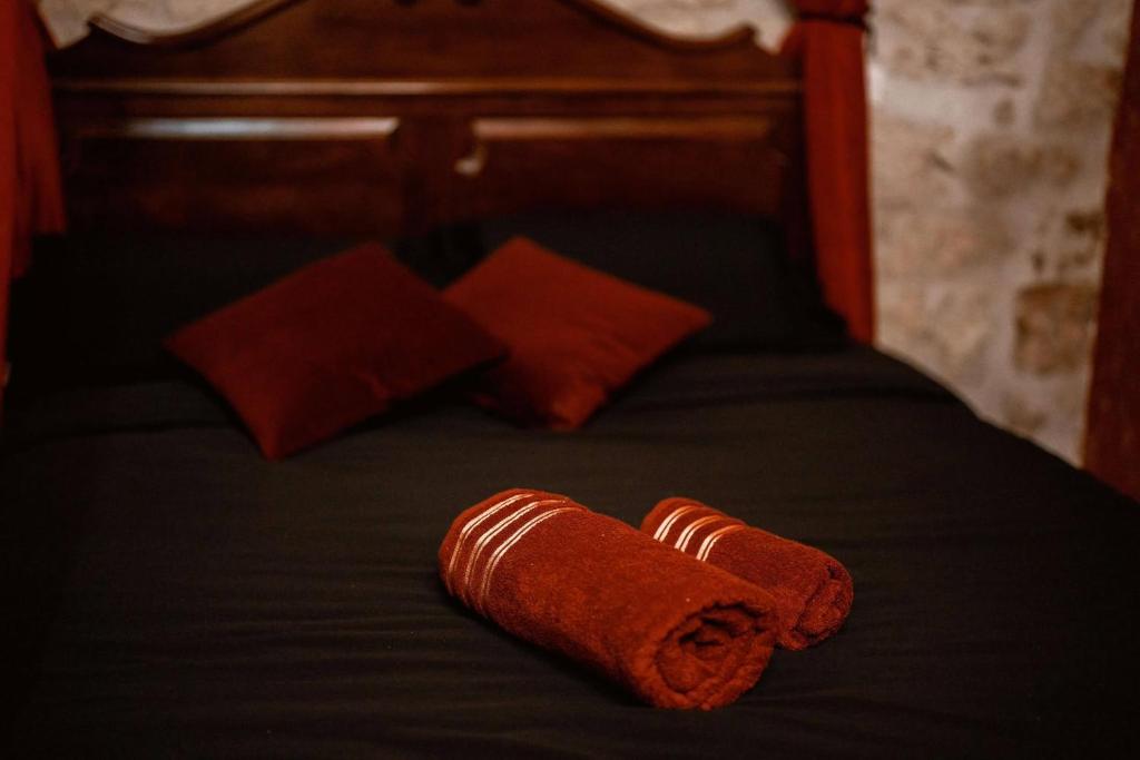 a brown towel is laying on a bed at Les sorciers de Lauzerte immersion magique in Lauzerte
