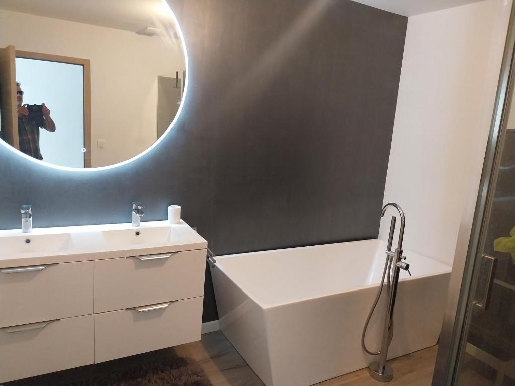 une salle de bain avec un lavabo blanc et un miroir dans l'établissement Maison entière, à Guidel