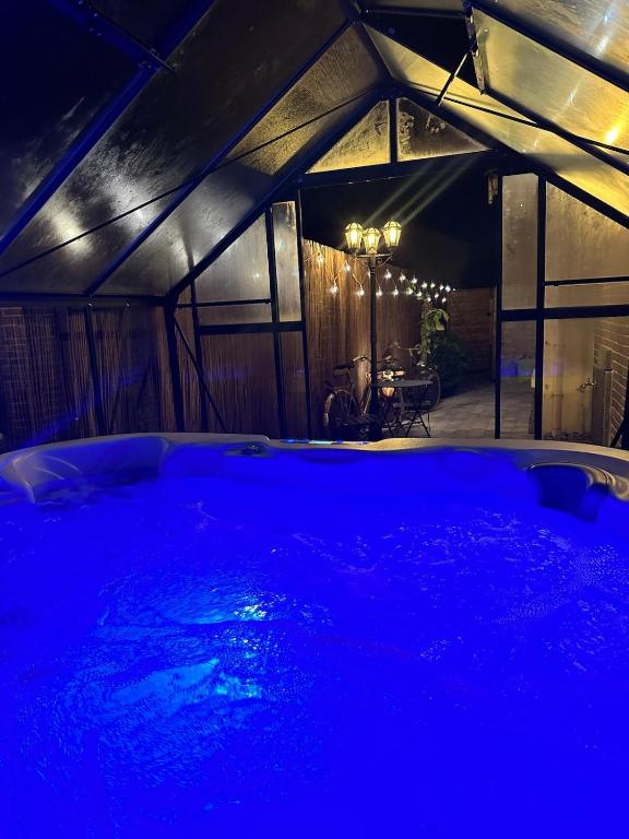 - un bain à remous dans une pièce à éclairage bleu dans l'établissement Love Room, Jacuzzi & Cinema House, à Mérignac
