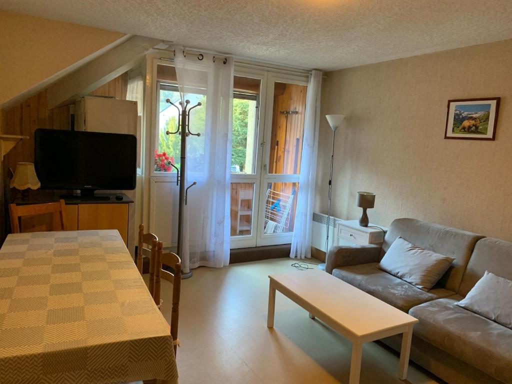 un salon avec un canapé et une table dans l'établissement Appartement St Lary Village, à Saint-Lary-Soulan