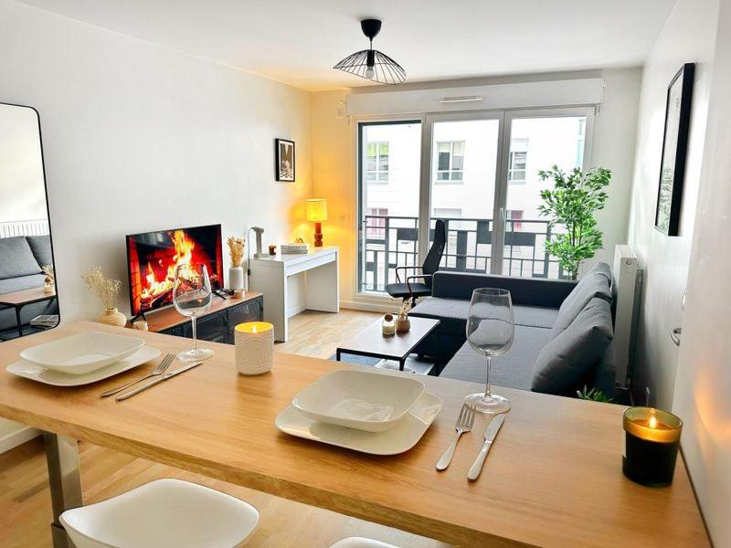 - un salon doté d'une table avec des assiettes et des verres à vin dans l'établissement Appartement cosy aux portes de Paris, à Levallois-Perret