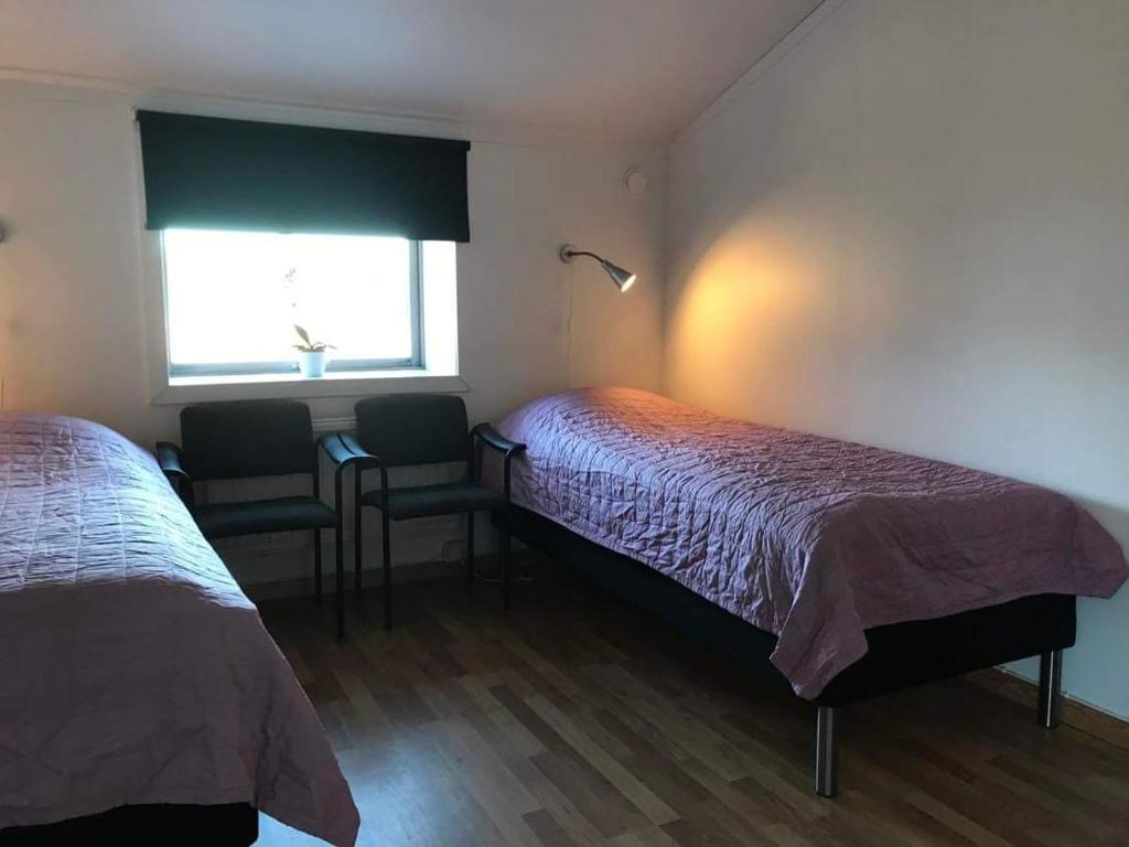 a room with two beds and a desk and a window at Stall Norrby in Norrby