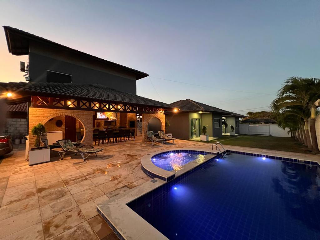 a swimming pool in the yard of a house at Chalés em Flecheiras in Trairi