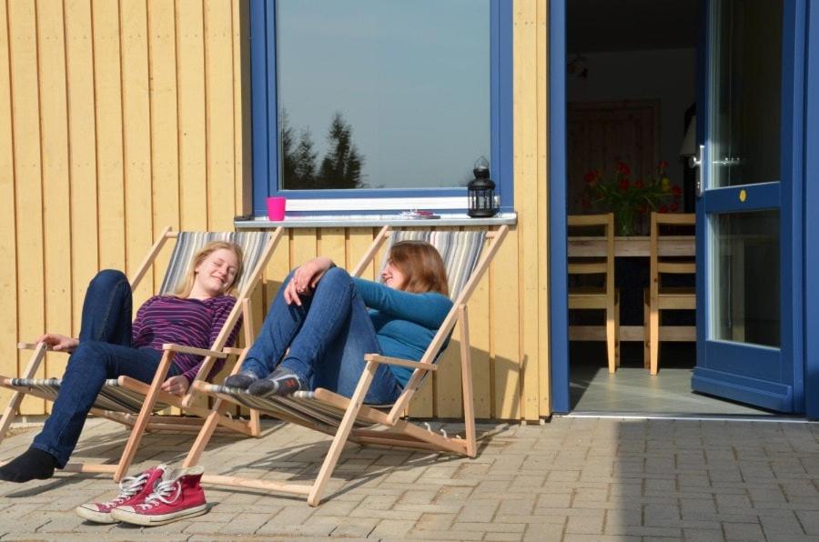 two women sitting in lawn chairs on a porch at FerienhausLychen in Lychen