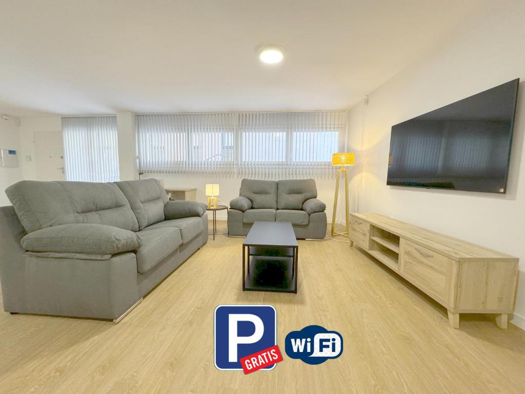a living room with two couches and a flat screen tv at Amplio Apartamento con Parking y en el Centro in Almería