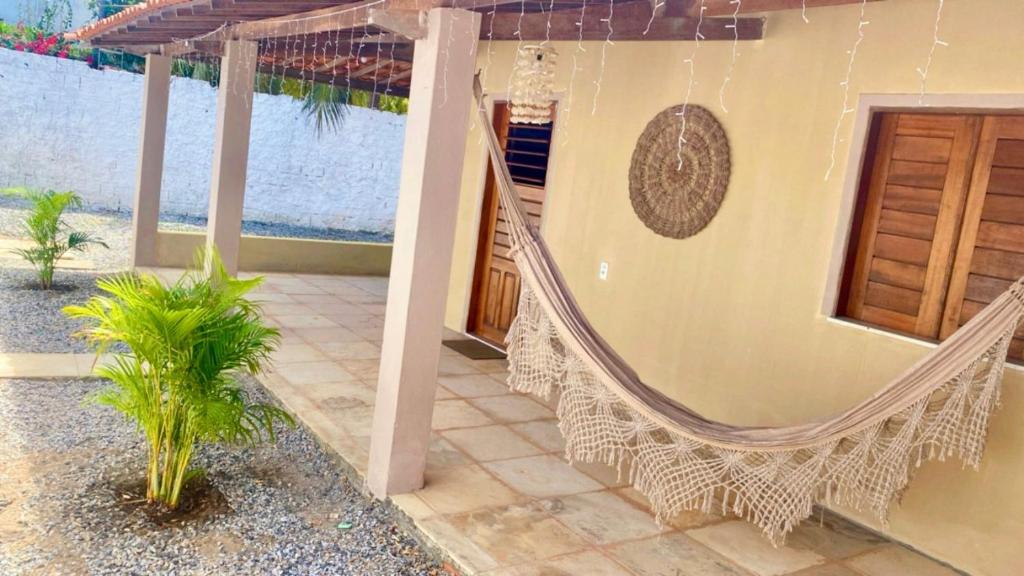 a hammock on the side of a house at Casa em Praia de Flecheiras in Trairi