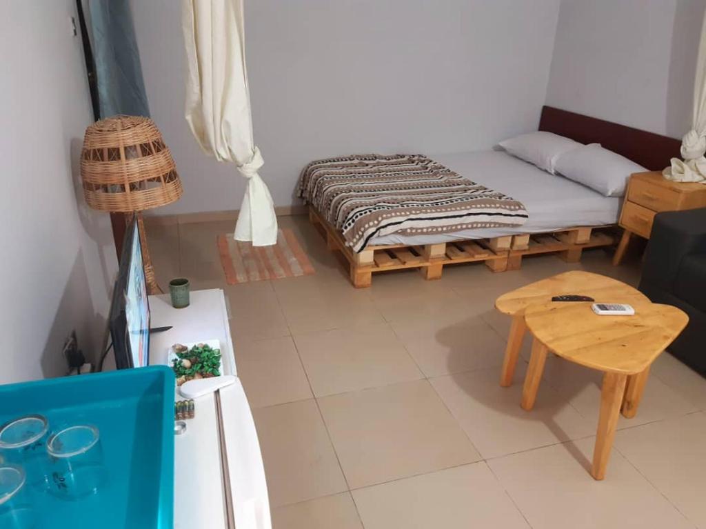 a small room with a bed and a table at Apparemment studio in Cotonou