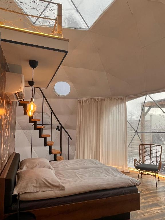 a bedroom with a bed next to a staircase at Glamping Liptov in Liptovský Trnovec