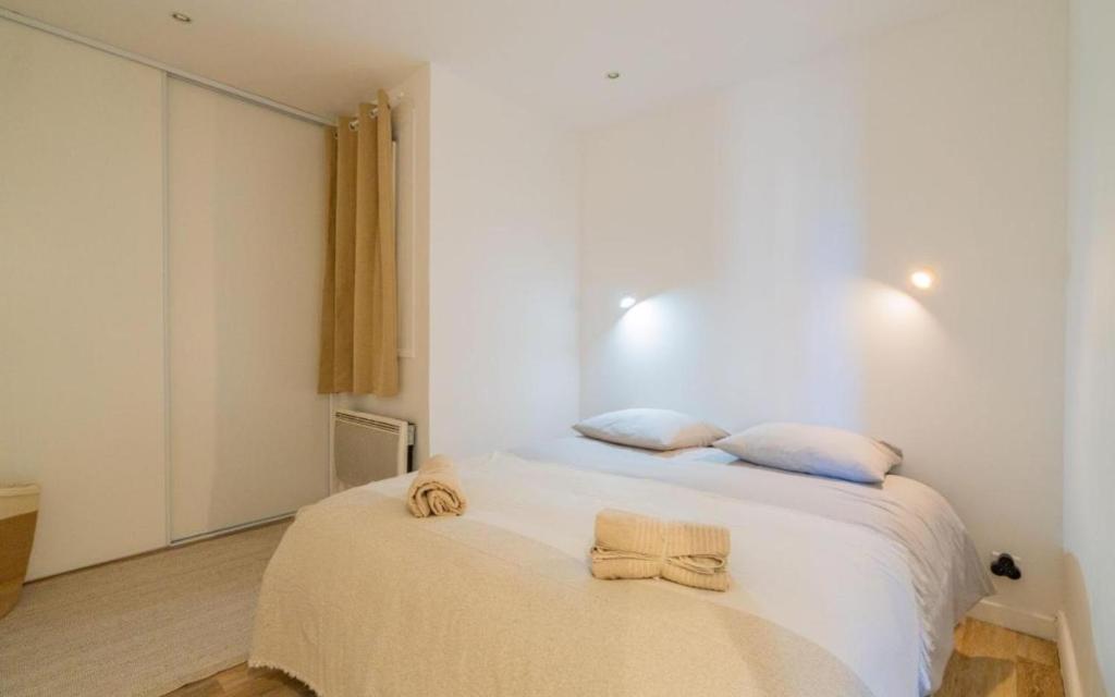 une chambre avec un lit avec des serviettes dessus dans l'établissement Joli T2 quartier de la Joliette 2 min du tramway, à Marseille