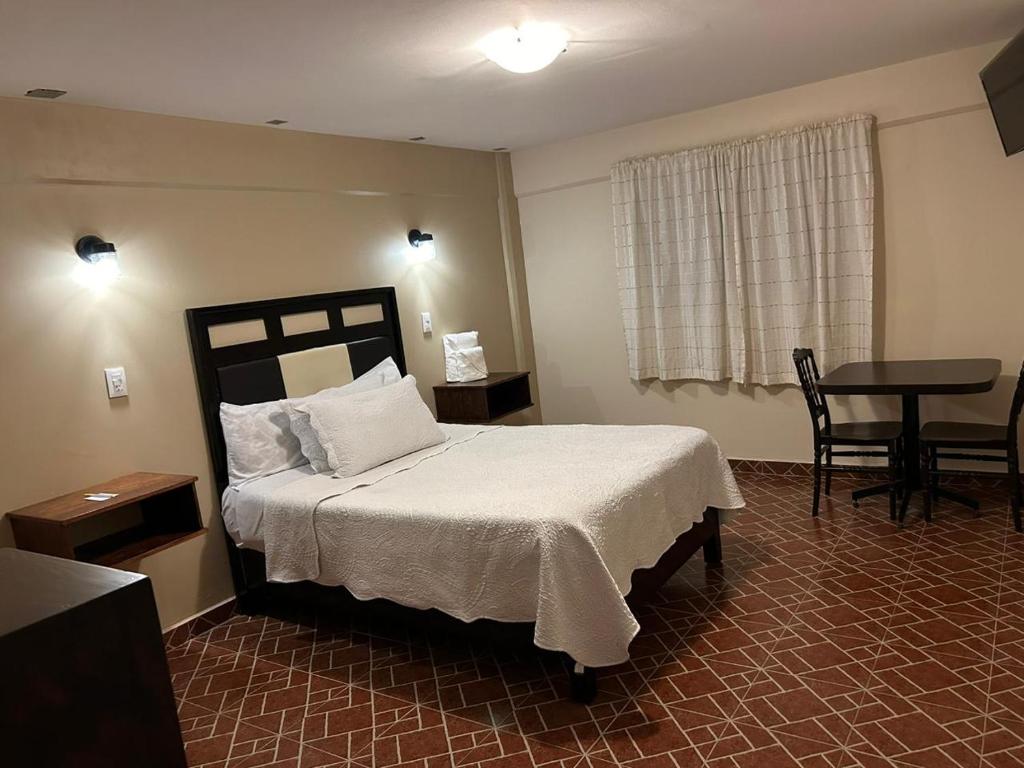 Un dormitorio con una cama y una mesa en una habitación. en HOTEL GOLD, en El Oro de Hidalgo