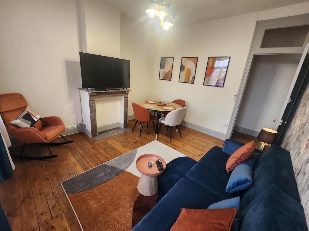 un salon avec un canapé bleu et une table dans l'établissement L 'Échappée Cambrésienne, à Cambrai