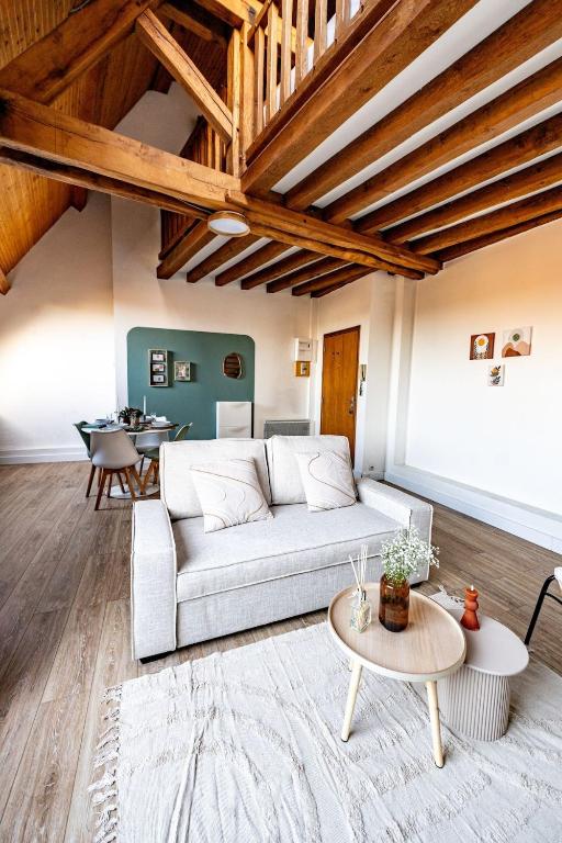 un salon avec un canapé et une table dans l'établissement Le Cocon sous les toits, à Beauvais