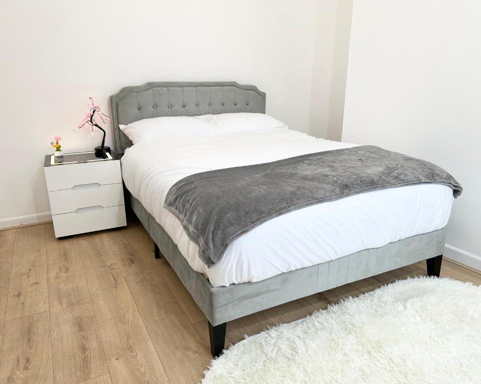 a bedroom with a bed and a white nightstand at 6-Sleeper 3BR Garden Beach - FREE parking in Portsmouth