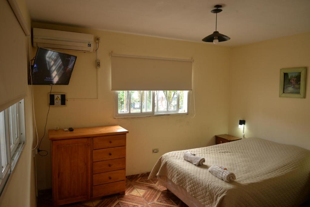 a bedroom with a bed and a dresser and a television at Departamentos temporarios La Nueva Costanera in Posadas