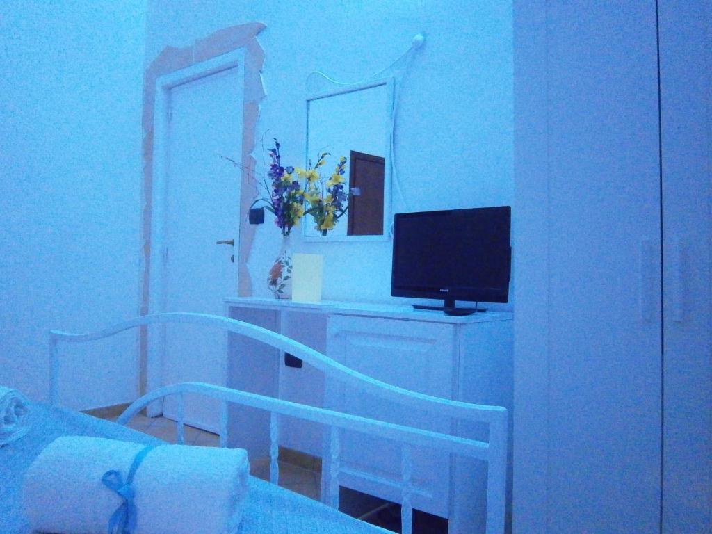 a bedroom with a bed and a television on a desk at B&B La Rosa Lampedusa in Lampedusa