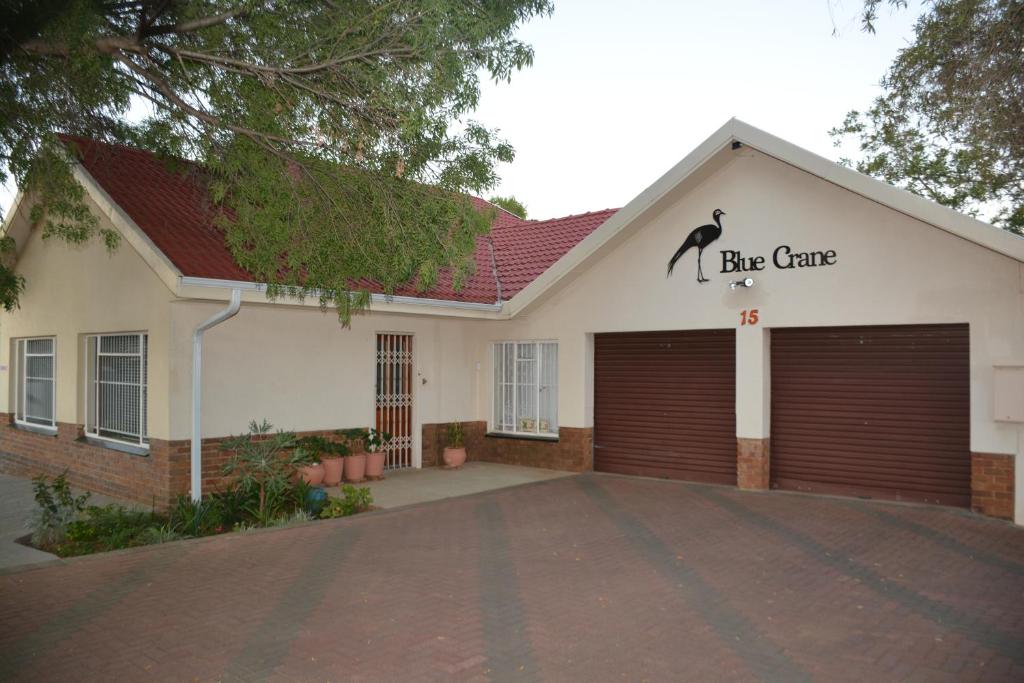 a large white garage with a black cat on the top at Blue Crane Guest House Bloemfontein in Bloemfontein
