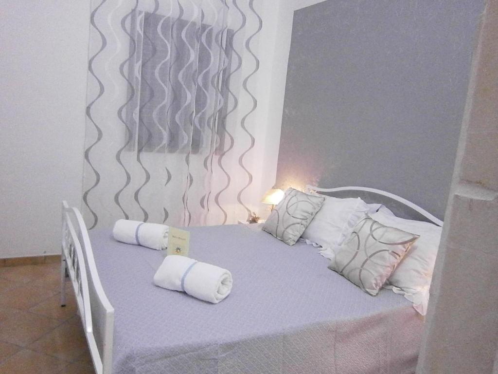a bed with white pillows and towels on it at B&B La Rosa Lampedusa in Lampedusa