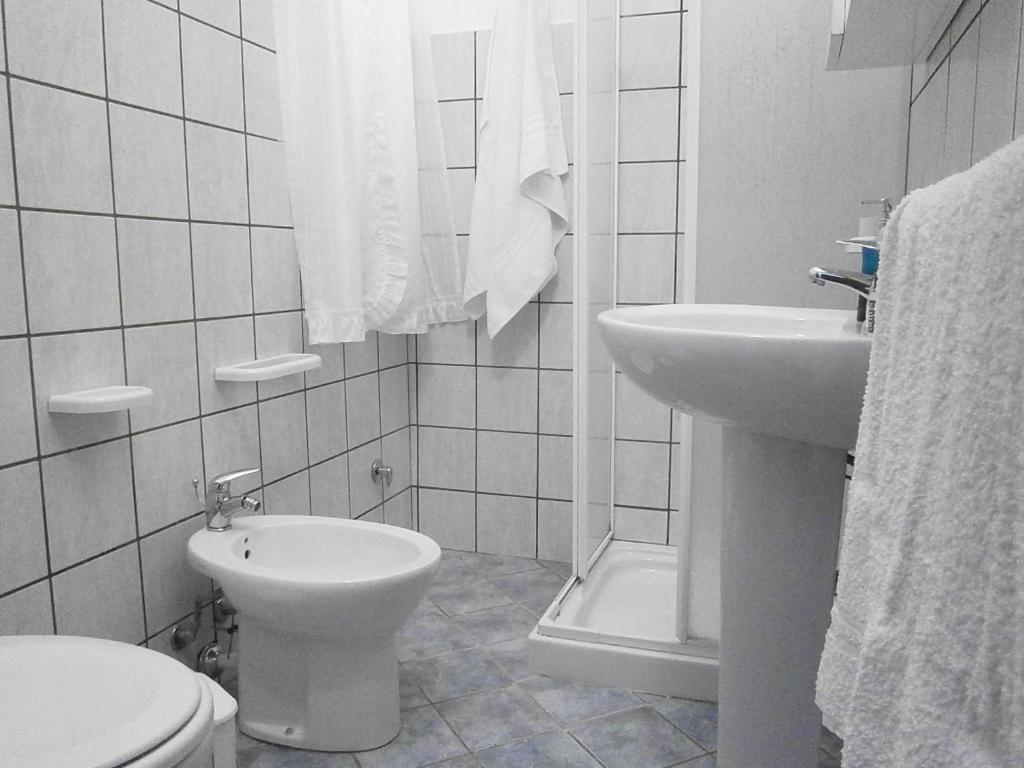 a white bathroom with a toilet and a sink at B&B La Rosa Lampedusa in Lampedusa