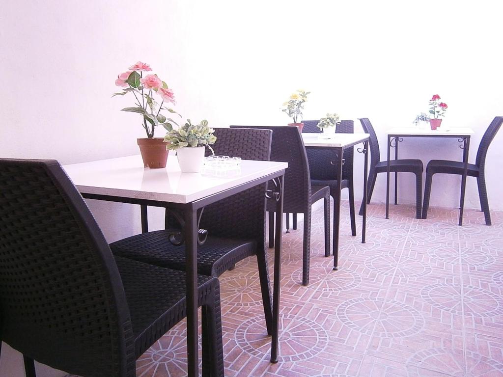 a row of tables and chairs with flowers on them at B&B La Rosa Lampedusa in Lampedusa