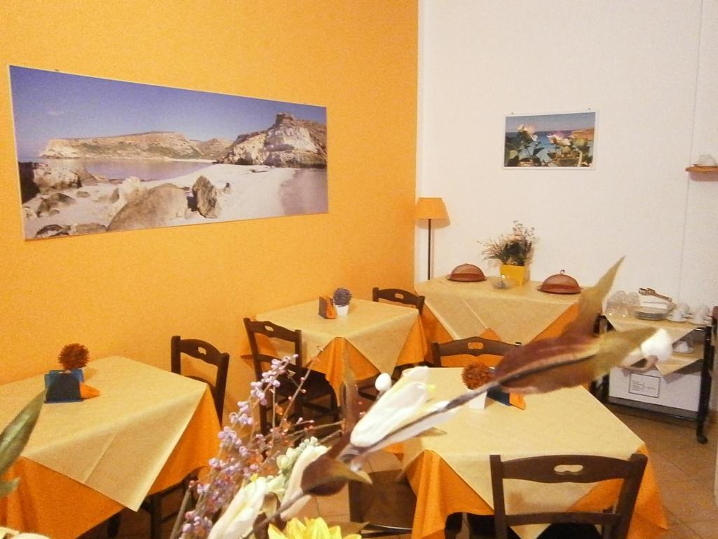 a dining room with two tables with yellow walls at B&B La Rosa Lampedusa in Lampedusa