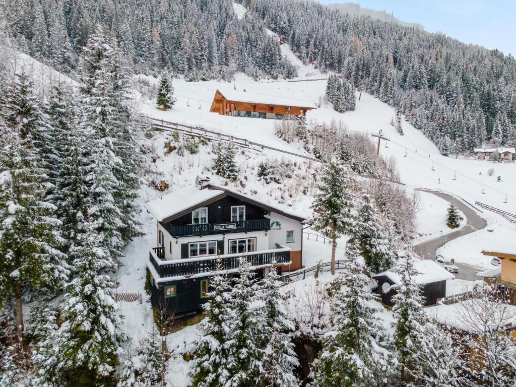 a house is covered in snow in a mountain at Villa Taube in Bad Gastein