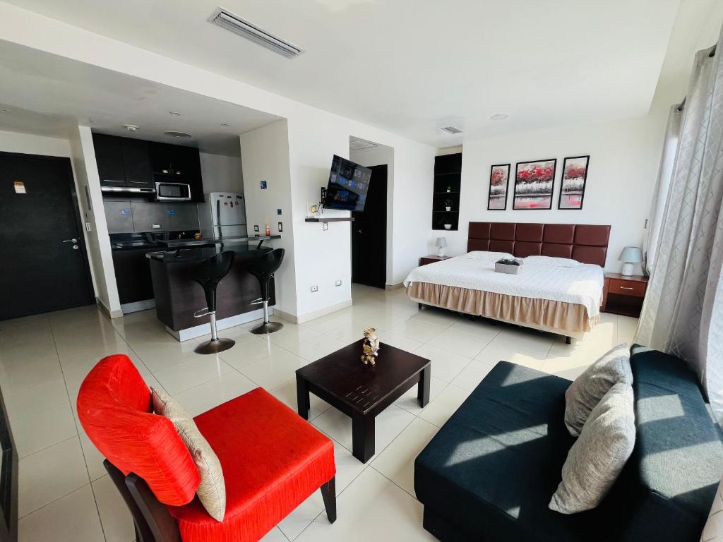 un ampio soggiorno con un letto e un divano di Hermosa Suite - Piscina - Gym - City Suites - 1403 a Guayaquil