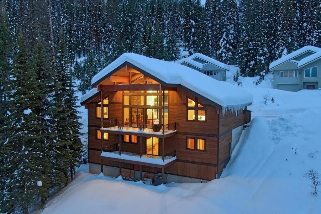 a log cabin in the snow with the lights on at Ski-InandSki-Out Schweitzer Mtn Home Decks and Views! in Sandpoint