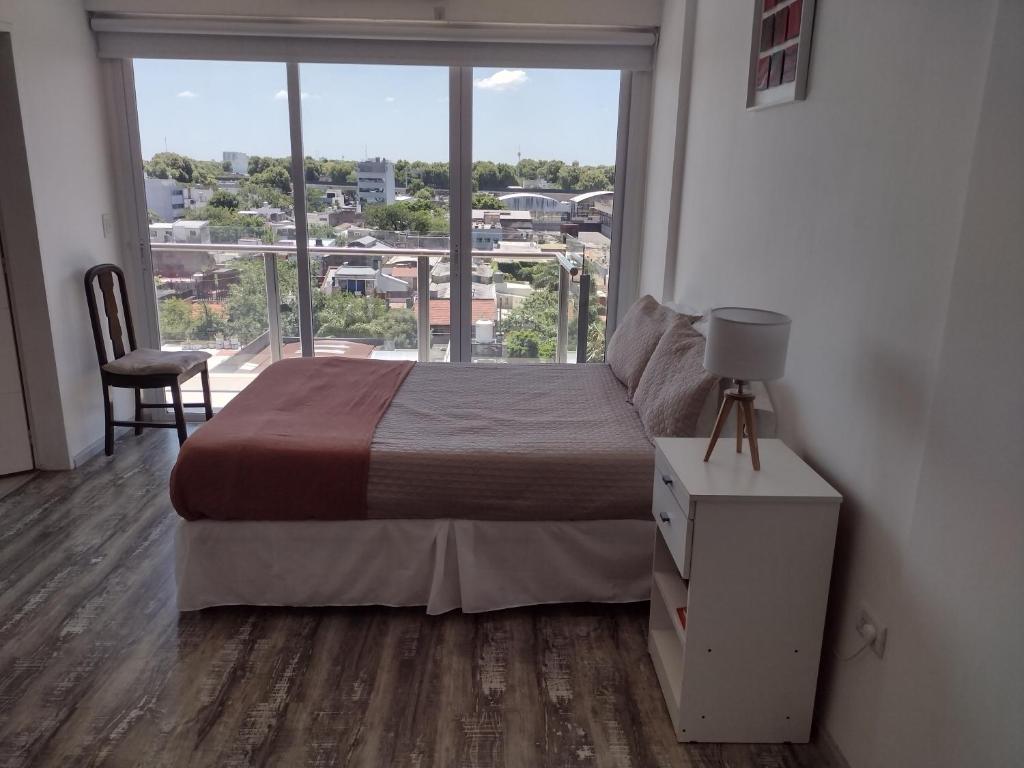 Un dormitorio con una cama y una ventana grande en Movistar Arena, en Buenos Aires