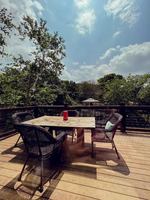 a wooden table and chairs on a wooden deck at Treehouse 1 Mockingbird Lodge in New Braunfels