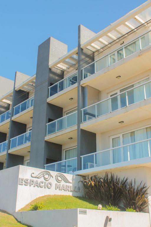 an apartment building with a sign in front of it at Complejo Espacio Marina in Villa Gesell
