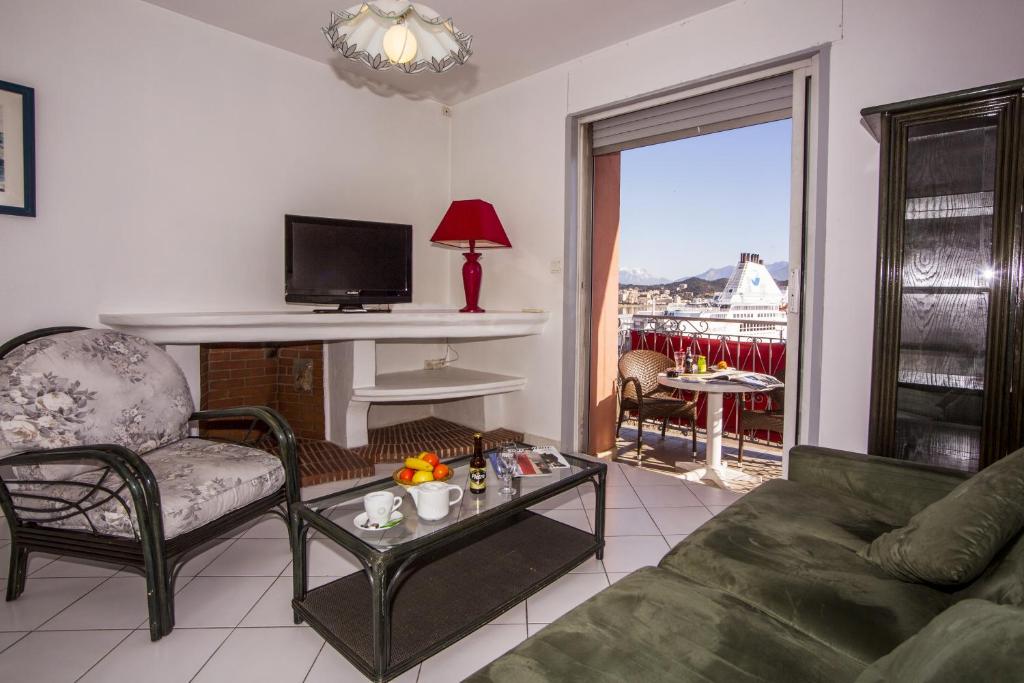 a living room with a couch and a tv at Hotel le Dauphin in Ajaccio