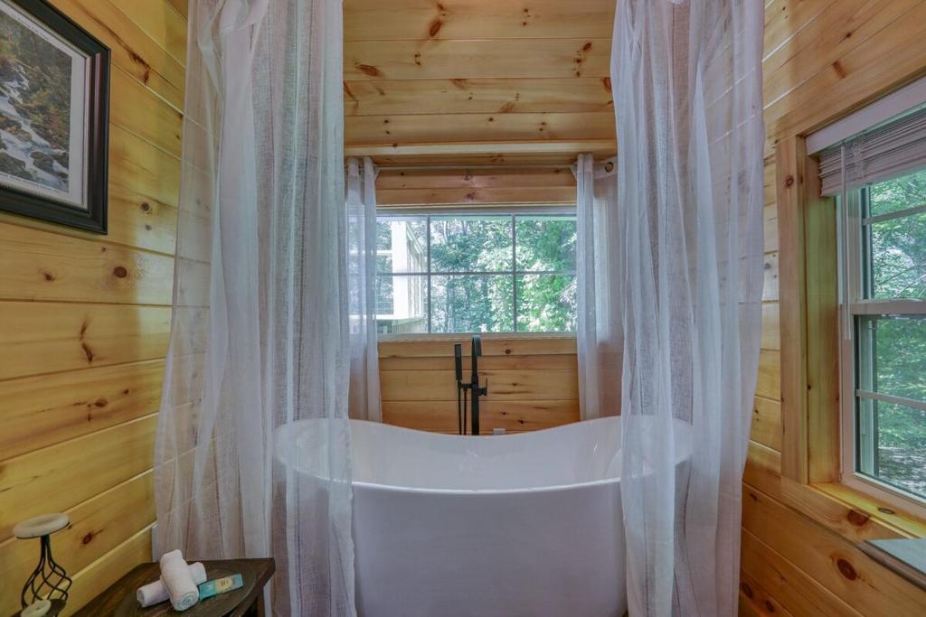 a white tub in a bathroom with a window at Firefly Haven - Summer Oasis with HOT TUB in Gatlinburg