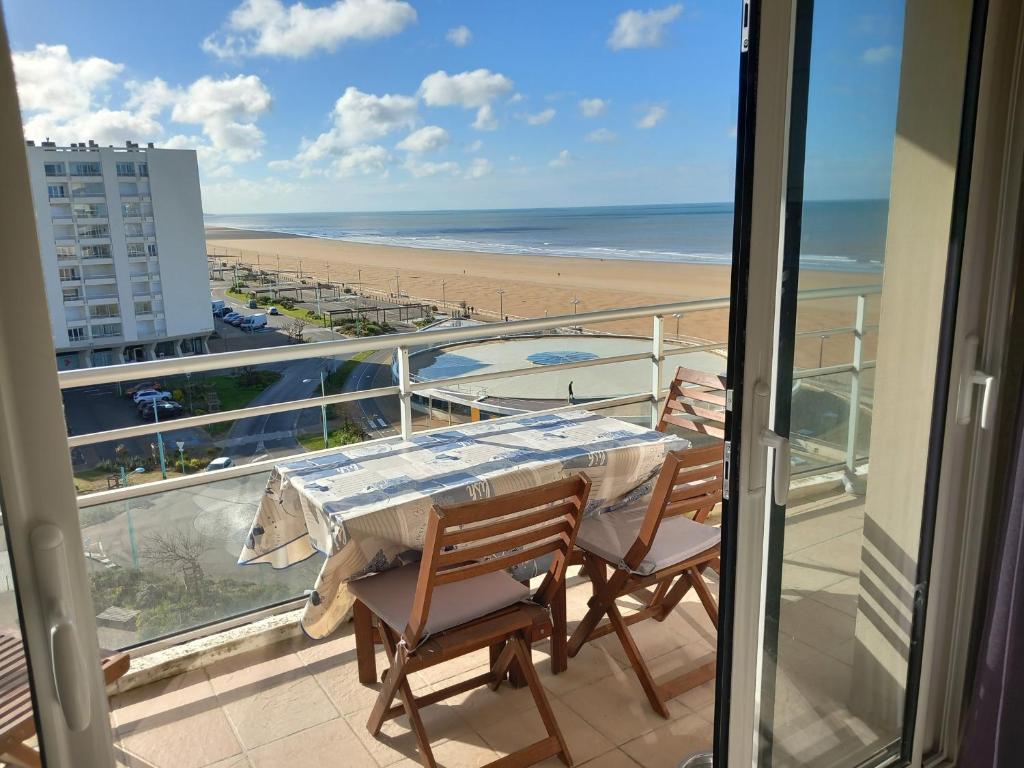 un balcon avec une table et des chaises et une plage dans l'établissement Appartement 2 chambres avec Wi-Fi, vue mer, proche plage à Saint-Jean-de-Monts - FR-1-323-136, à Saint-Jean-de-Monts