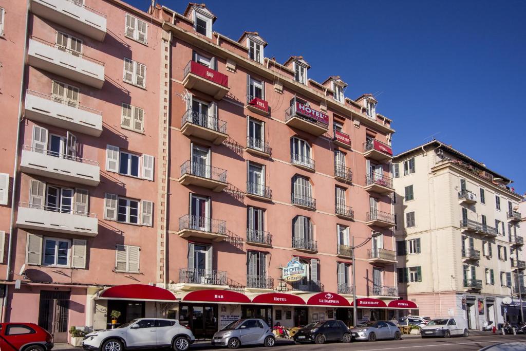 a large building with cars parked in front of it at Hotel le Dauphin in Ajaccio