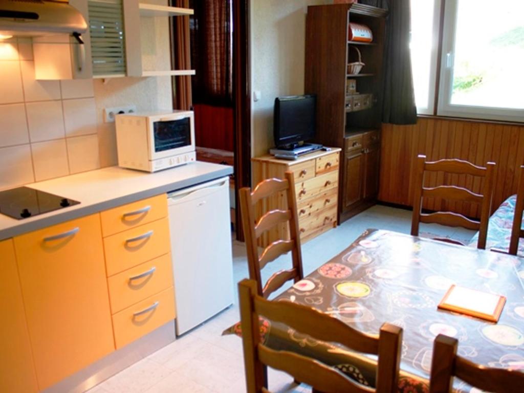 une petite cuisine avec une table et un micro-ondes dans l'établissement Confort fonctionnel, navette au pied, proche centre & pistes - FR-1-814-29, à Besse-et-Saint-Anastaise